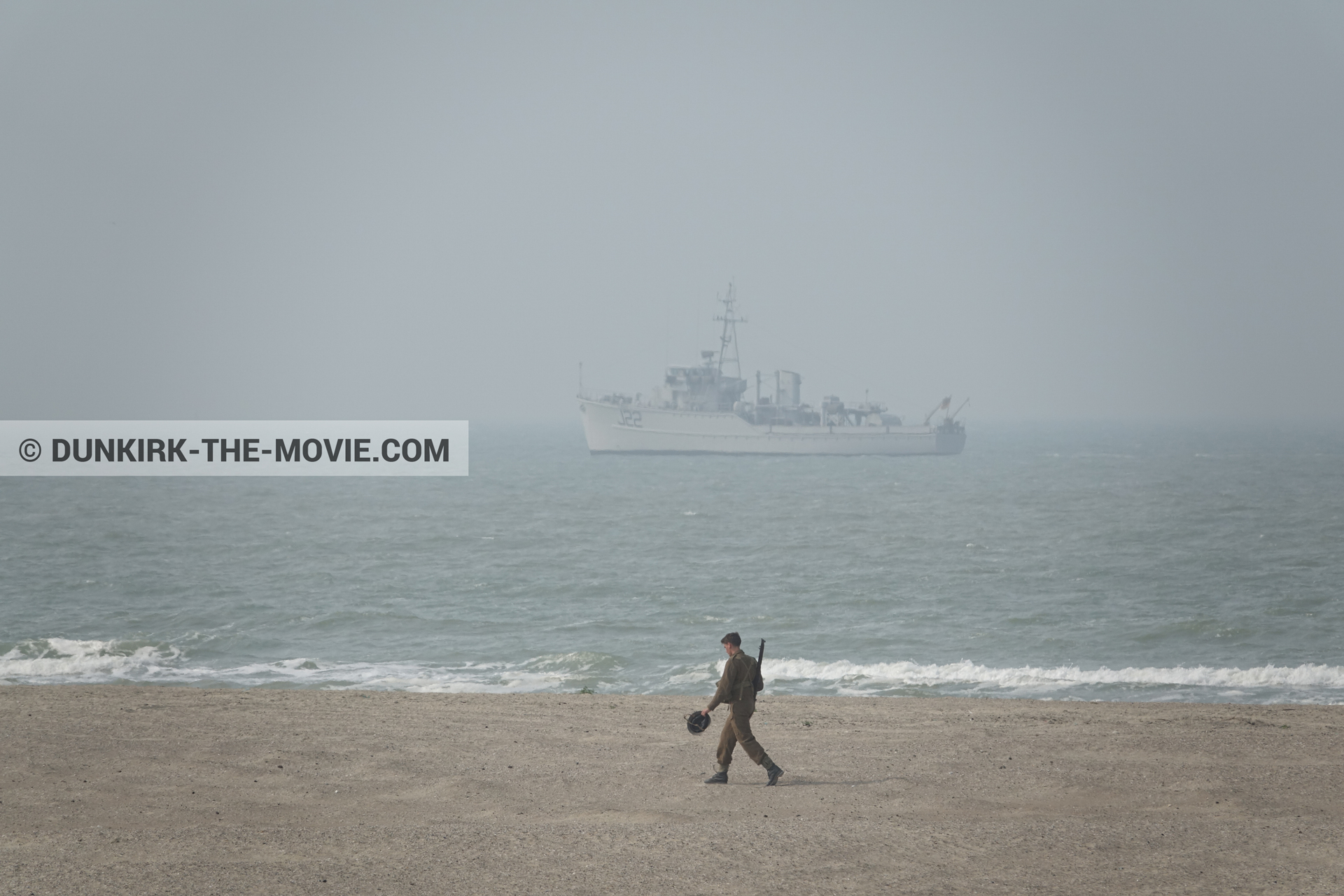 Picture with boat, grey sky, supernumeraries, rough sea, beach,  from behind the scene of the Dunkirk movie by Nolan