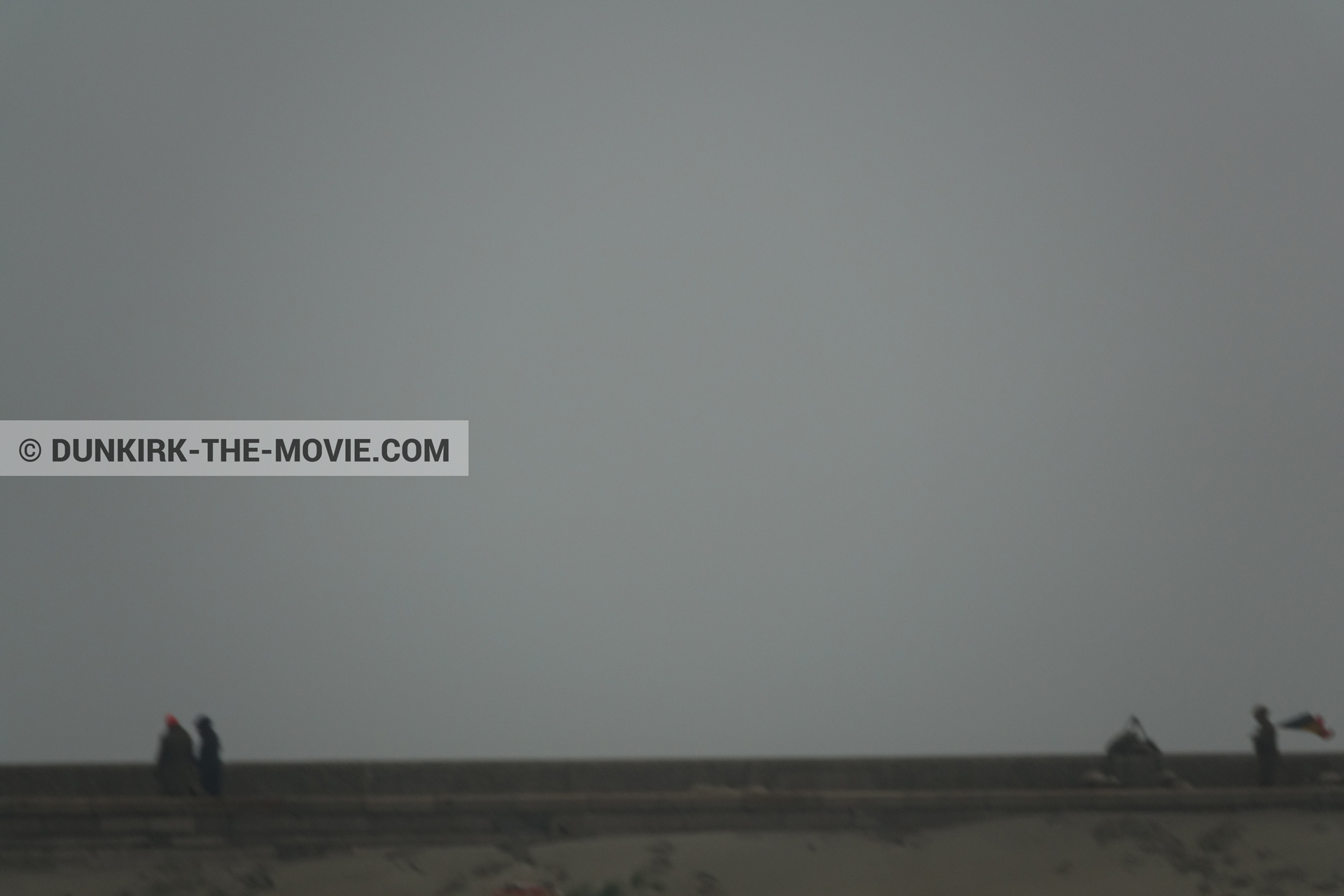 Photo avec ciel gris, figurants, jetée EST,  des dessous du Film Dunkerque de Nolan