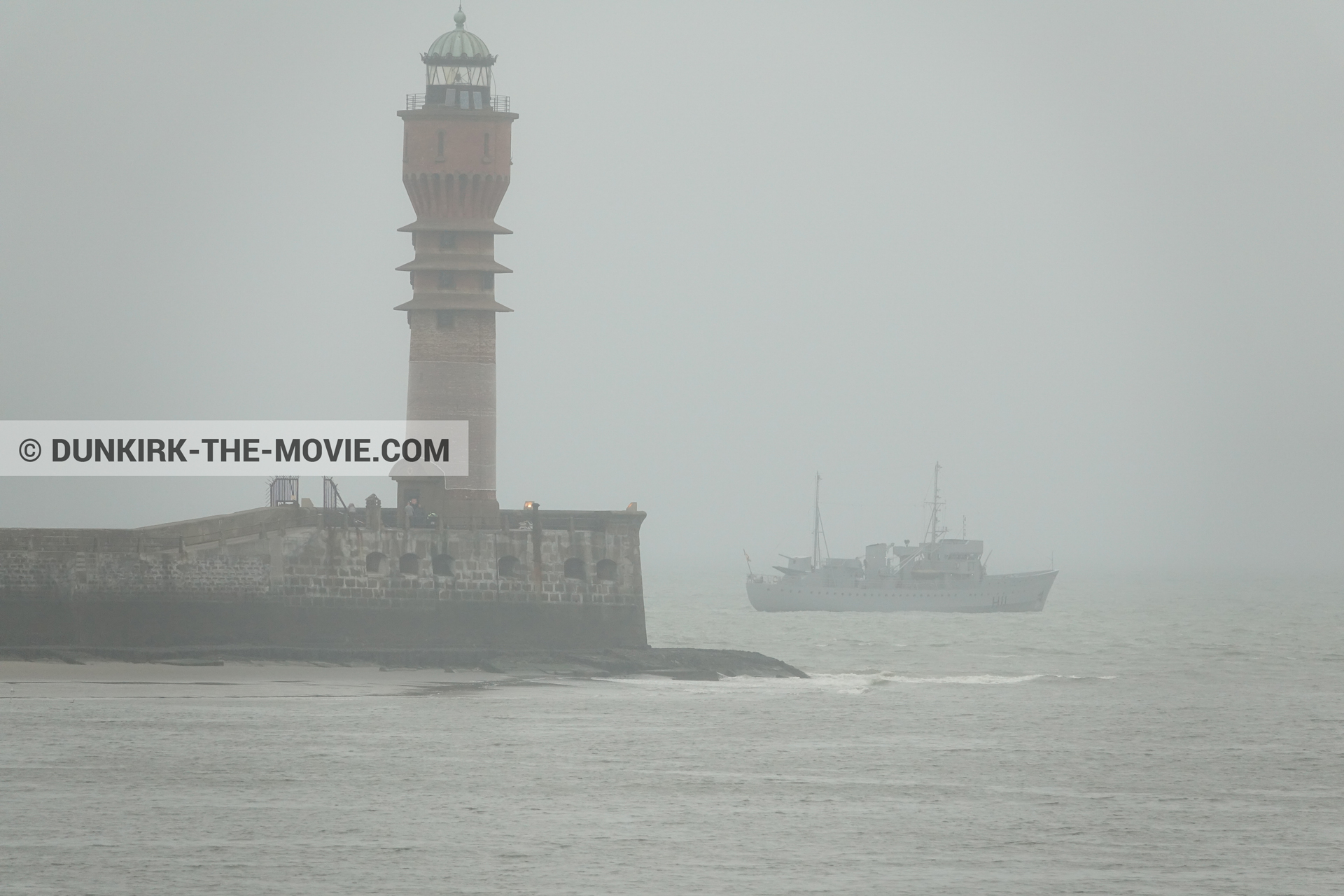 Picture with boat, grey sky, calm sea, St Pol sur Mer lighthouse,  from behind the scene of the Dunkirk movie by Nolan