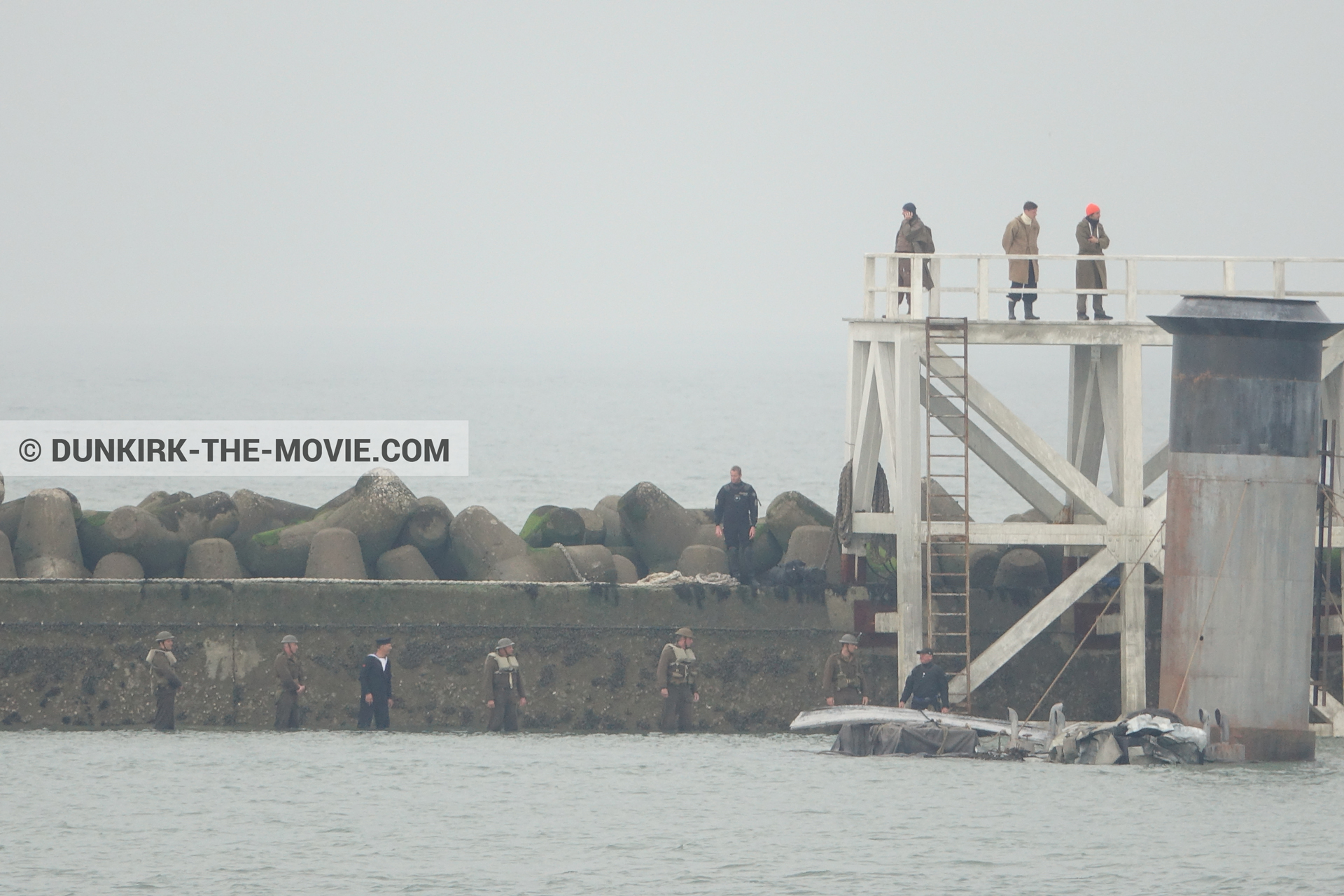 Picture with actor, grey sky, decor, supernumeraries, EST pier, calm sea, technical team,  from behind the scene of the Dunkirk movie by Nolan