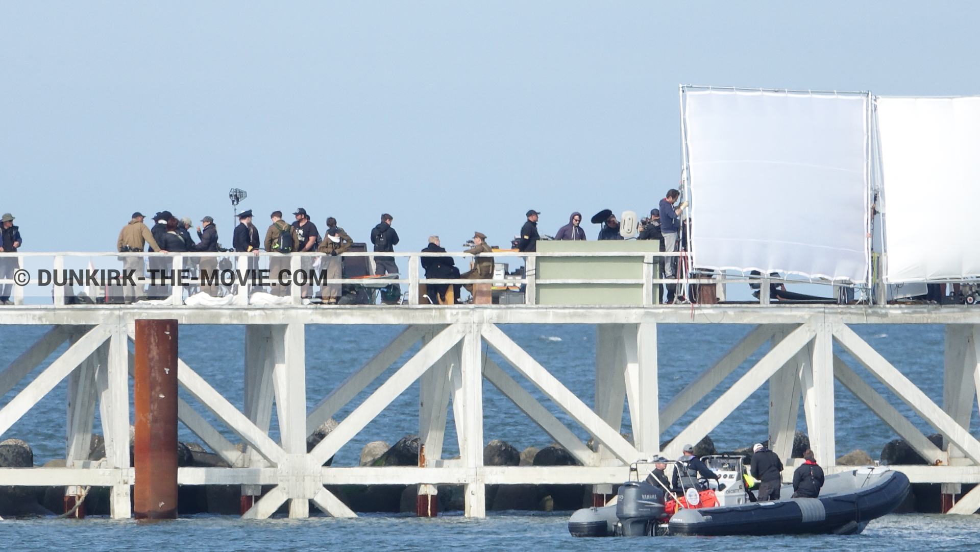 Picture with blue sky, EST pier, Kenneth Branagh, technical team, inflatable dinghy,  from behind the scene of the Dunkirk movie by Nolan