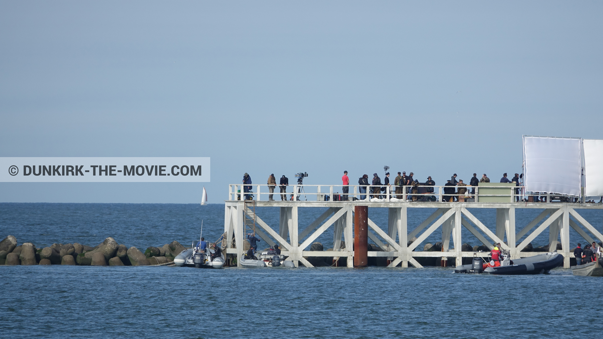 Picture with actor, IMAX camera, blue sky, EST pier, Kenneth Branagh, calm sea, technical team, inflatable dinghy,  from behind the scene of the Dunkirk movie by Nolan