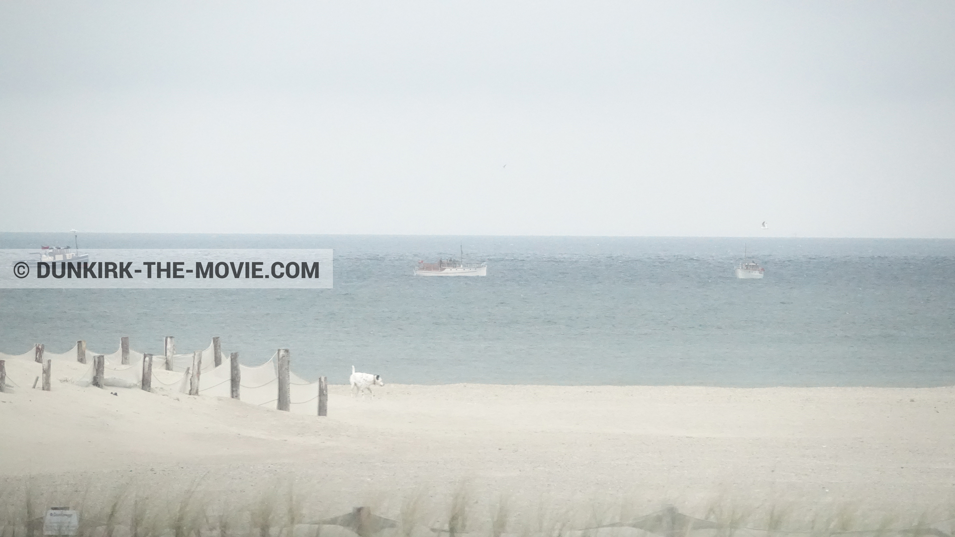 Picture with boat, grey sky, beach,  from behind the scene of the Dunkirk movie by Nolan