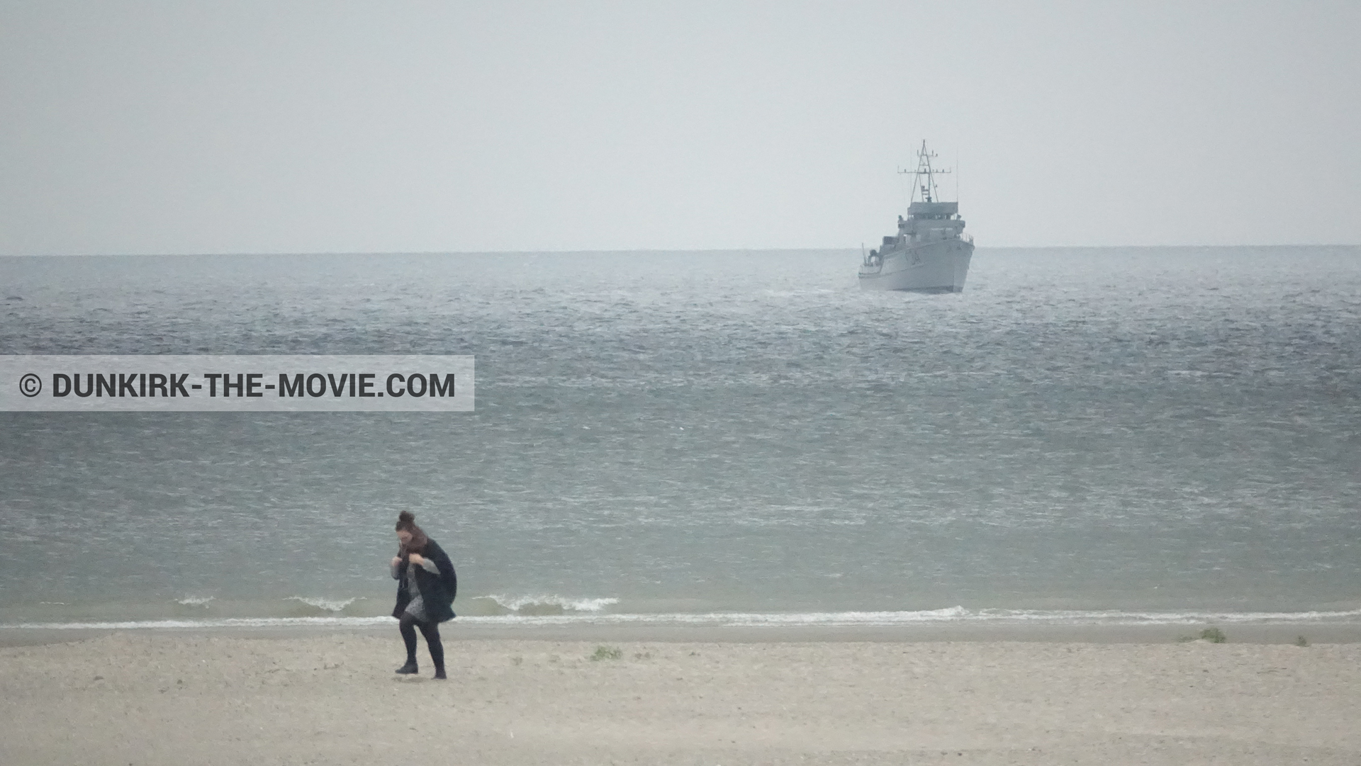 Picture with boat, grey sky, beach,  from behind the scene of the Dunkirk movie by Nolan