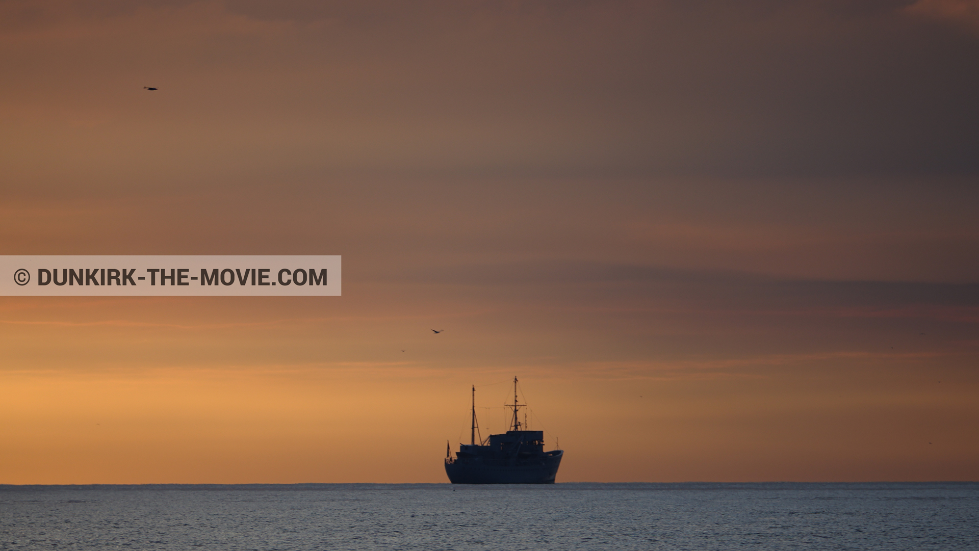 Photo avec bateau, ciel orangÃ©, mer calme,  des dessous du Film Dunkerque de Nolan