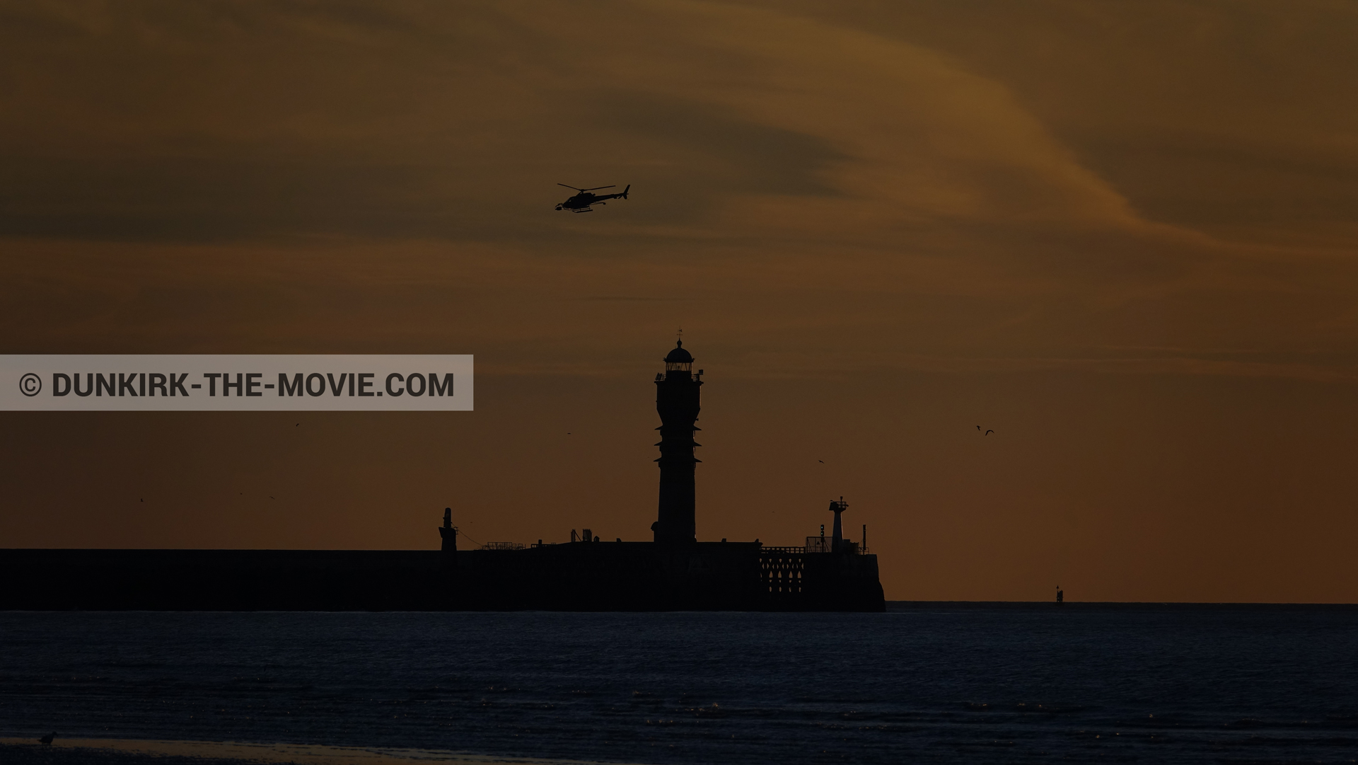 Photo avec ciel orangé, hélicoptère caméra,  des dessous du Film Dunkerque de Nolan