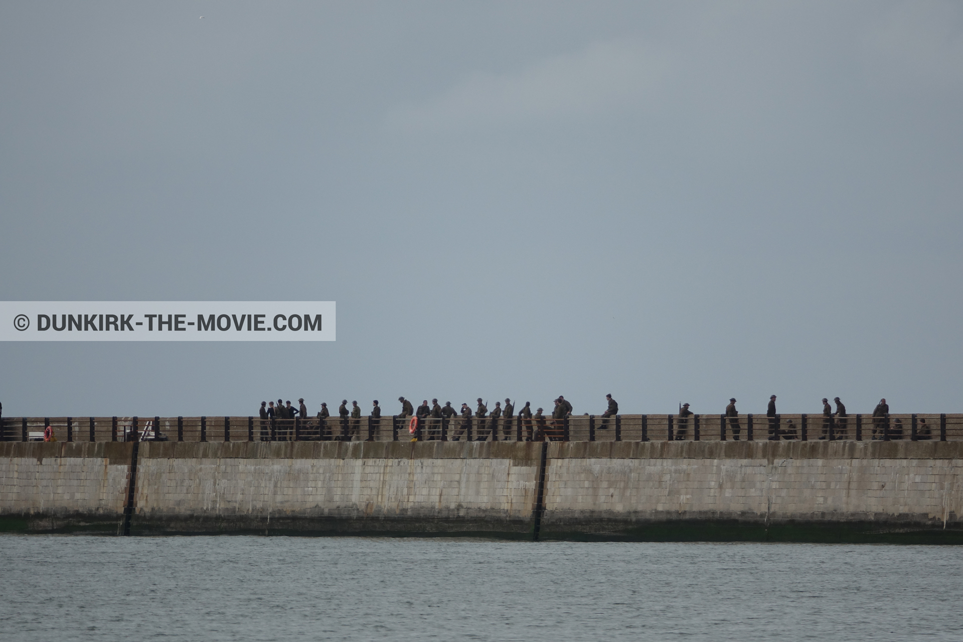 Picture with grey sky, supernumeraries, EST pier, calm sea,  from behind the scene of the Dunkirk movie by Nolan