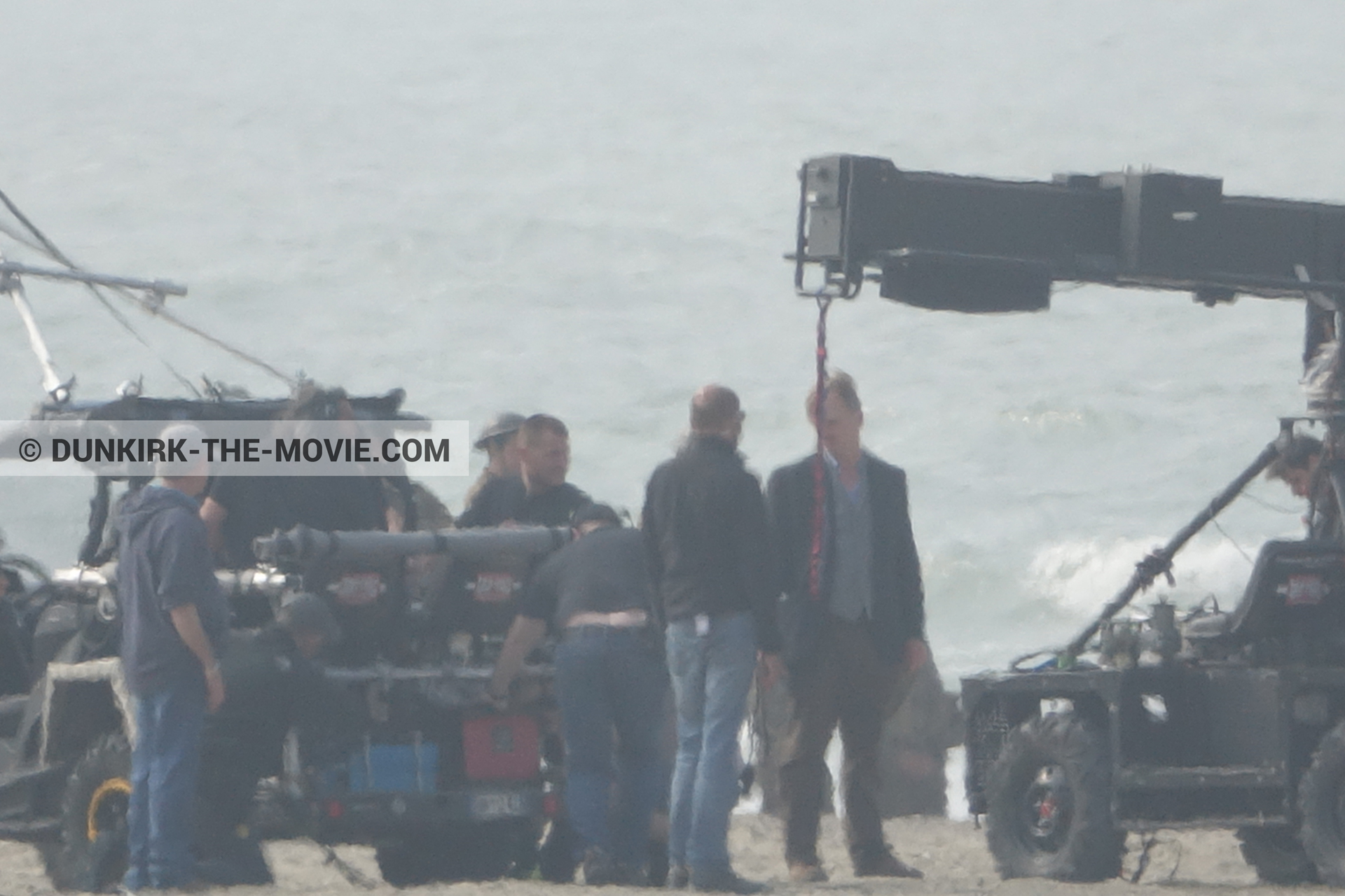 Picture with supernumeraries, Christopher Nolan, beach, technical team,  from behind the scene of the Dunkirk movie by Nolan