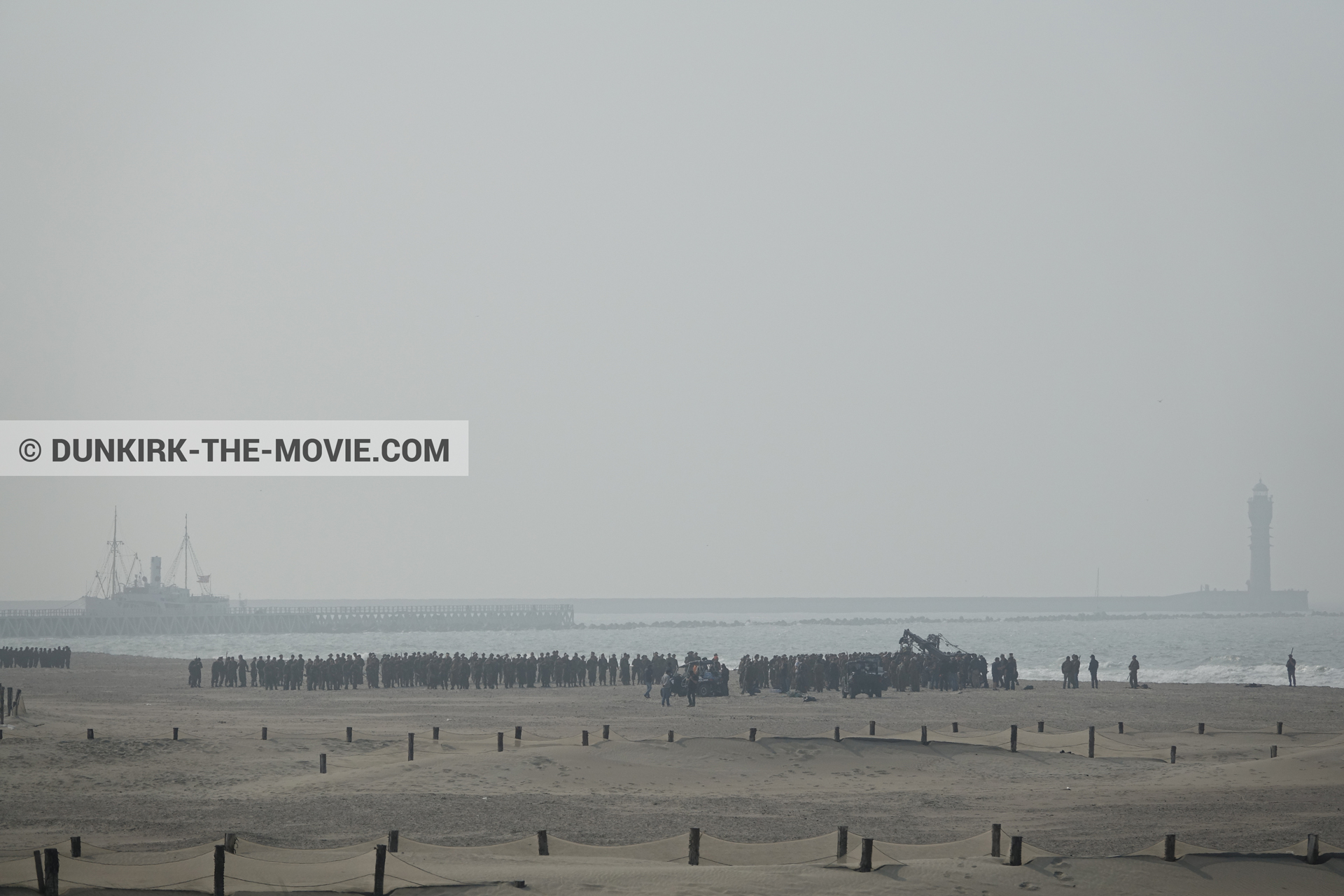 Picture with grey sky, supernumeraries, beach,  from behind the scene of the Dunkirk movie by Nolan