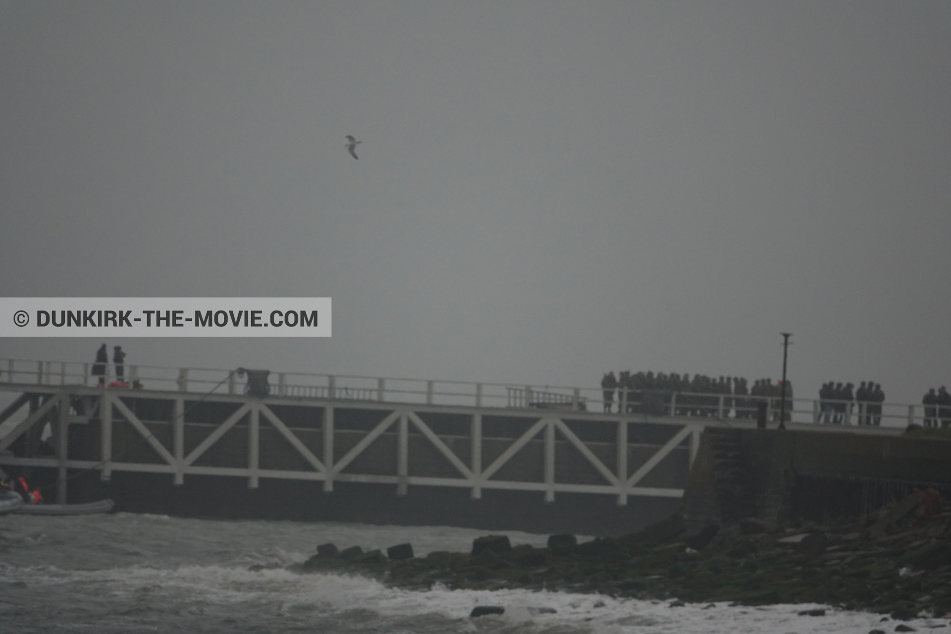 Picture with grey sky, supernumeraries, EST pier, rough sea,  from behind the scene of the Dunkirk movie by Nolan