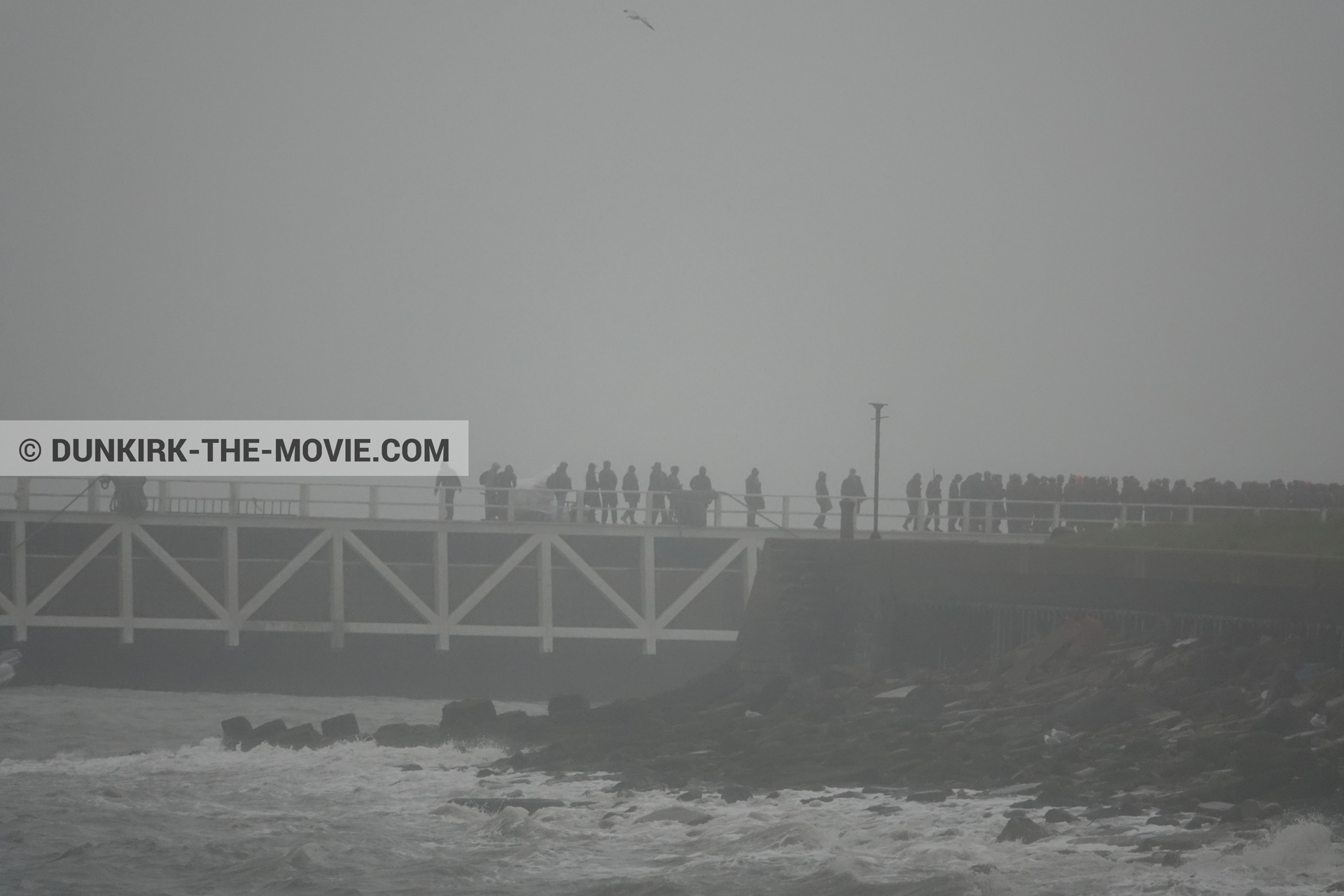Picture with grey sky, supernumeraries, EST pier, rough sea,  from behind the scene of the Dunkirk movie by Nolan