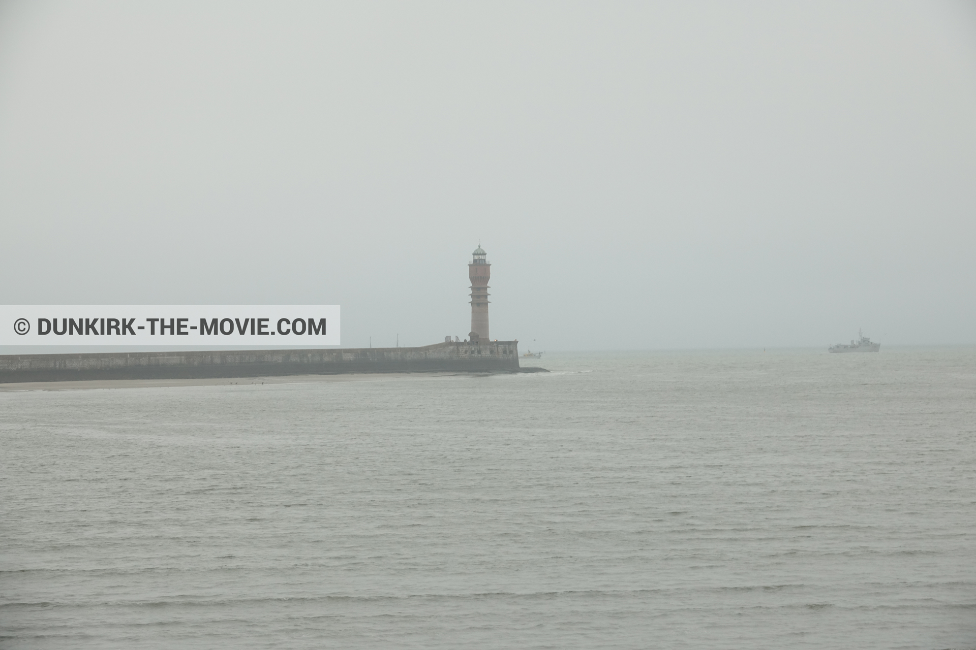 Picture with boat, grey sky, calm sea, St Pol sur Mer lighthouse,  from behind the scene of the Dunkirk movie by Nolan
