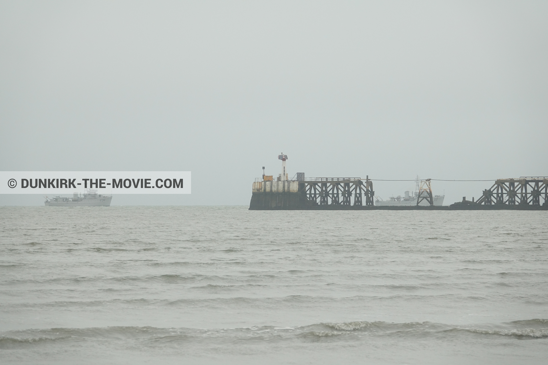 Picture with boat, grey sky, calm sea,  from behind the scene of the Dunkirk movie by Nolan