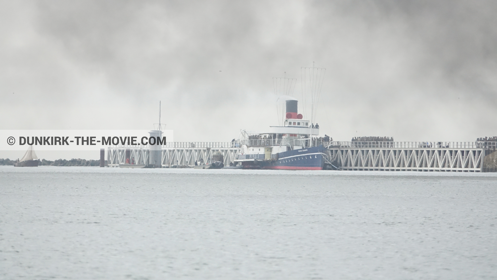 Photo avec ciel gris, décor, figurants, fumée noire, jetée EST, mer calme, Princess Elizabeth,  des dessous du Film Dunkerque de Nolan