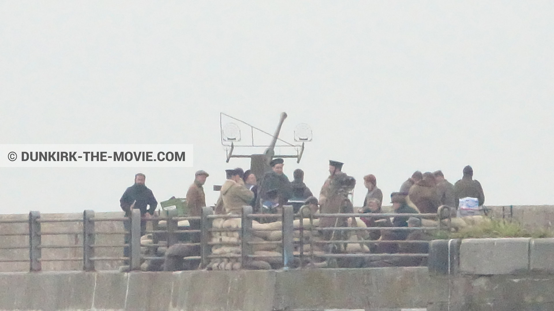 Picture with cannon, grey sky, supernumeraries, EST pier, technical team,  from behind the scene of the Dunkirk movie by Nolan
