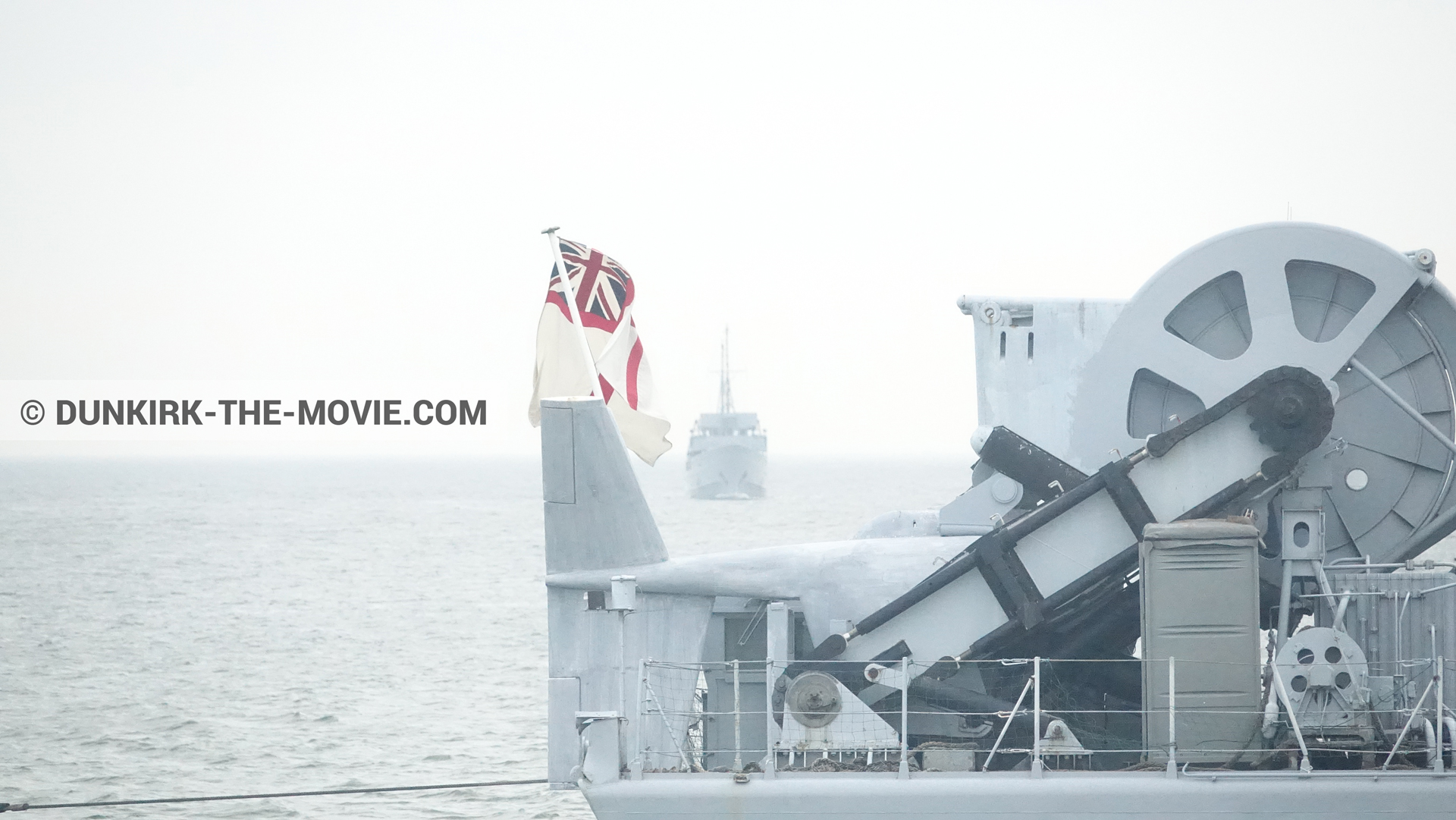 Picture with calm sea, grey sky, boat,  from behind the scene of the Dunkirk movie by Nolan