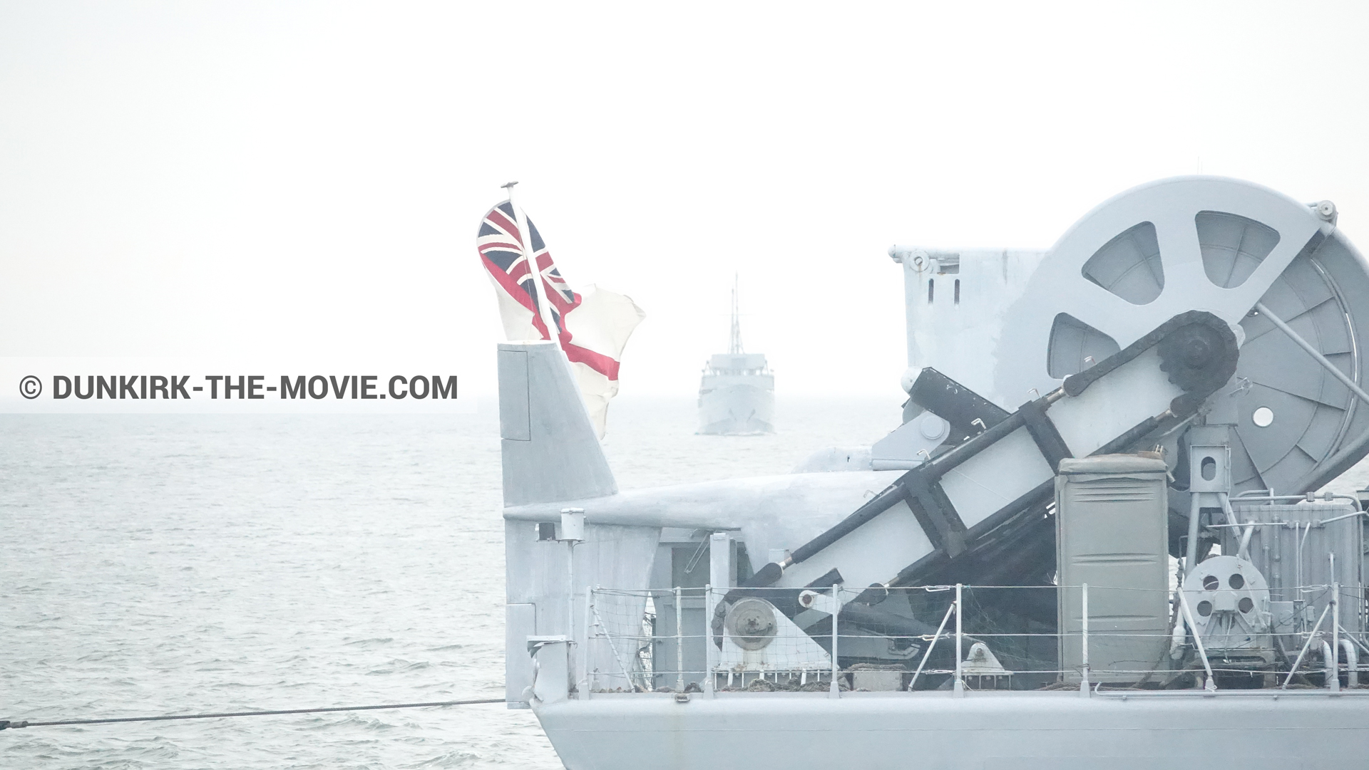 Picture with calm sea, grey sky, boat,  from behind the scene of the Dunkirk movie by Nolan