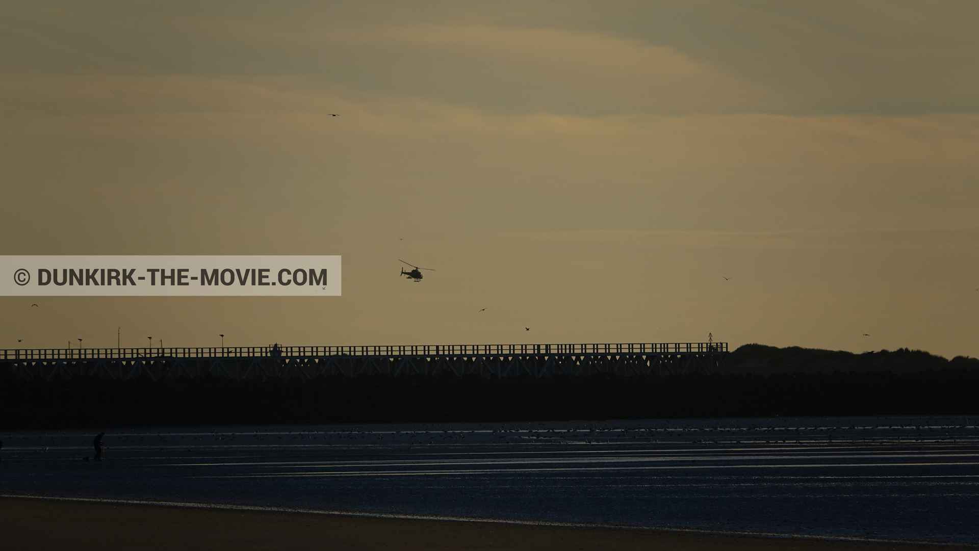 Photo avec ciel orangé, hélicoptère caméra,  des dessous du Film Dunkerque de Nolan
