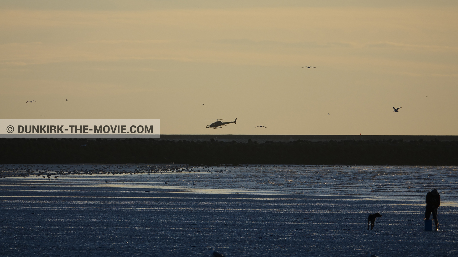 Picture with orange sky, helicopter camera, calm sea,  from behind the scene of the Dunkirk movie by Nolan